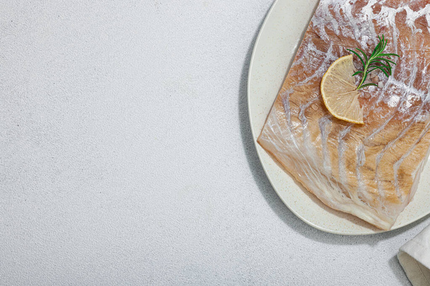 ロープロック(パロキウスウイルス)フィレット. 健康的な食生活のための新鮮な魚. レモン,ローズマリー,シーソルト,チリ,ブラックペッパーコーン。 ライトストーンコンクリート背景,フラットレイ,トップビュー - 写真・画像