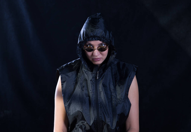 portrait d'une fille avec des lunettes et une capuche noire - Photo, image