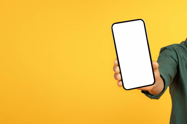Recommendation. Black guy hand holding big smartphone with white blank screen, showing close to camera nice mobile app. Gadget with empty free space for mock up, banner - Photo, Image