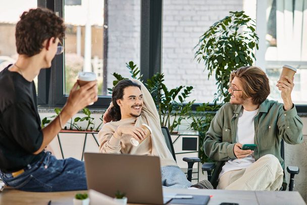 веселые молодые люди в возрасте 20 лет болтают во время кофе-брейка в офисе, члены команды стартапов - Фото, изображение