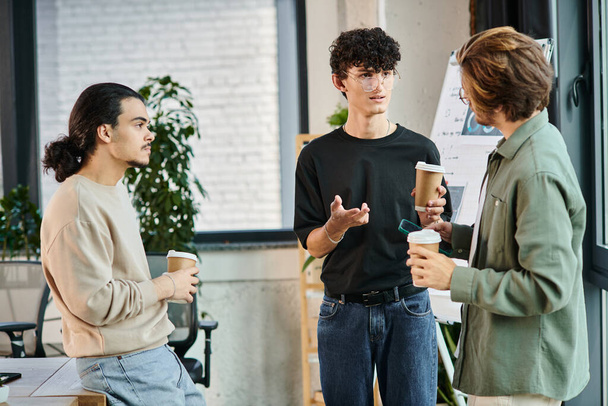 jeunes collègues dans la vingtaine partageant des idées autour d'un café dans un cadre de bureau moderne, équipe de démarrage - Photo, image