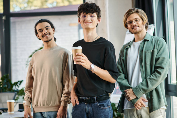 Троє молодих чоловіків у 20-х роках з кавою в дружній офісній атмосфері, професійний головний убір - Фото, зображення