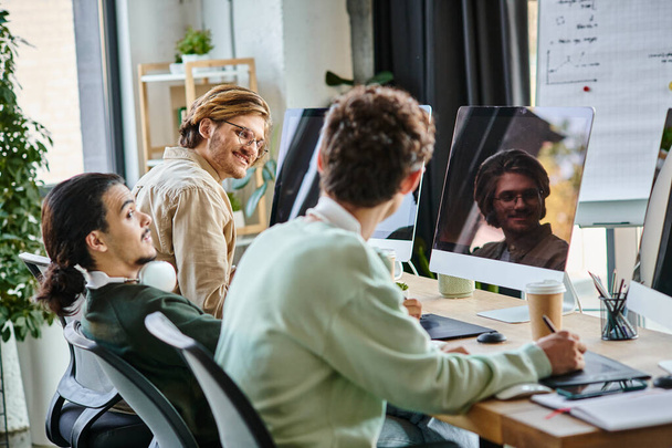 equipe de pós-produção discutindo projeto perto de gadgets para retocar no escritório, homens alegres em 20s - Foto, Imagem