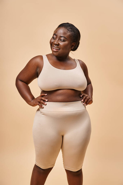 happy plus size woman in underwear posing with hands on hips, body positive and female empowerment - Photo, Image