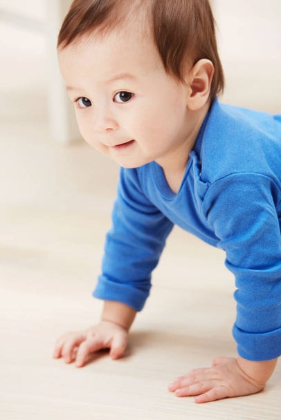 Cute, crawling and smile with baby on floor for child development, learning and youth. Young, curious and adorable with infant kid on ground of family home for growth, progress and first steps. - Photo, Image