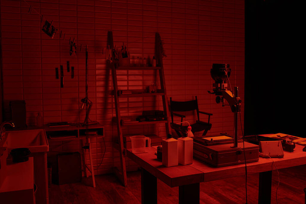 donkere kamer interieur met chemische flessen en gereedschappen, presentatie van het proces van filmontwikkeling - Foto, afbeelding