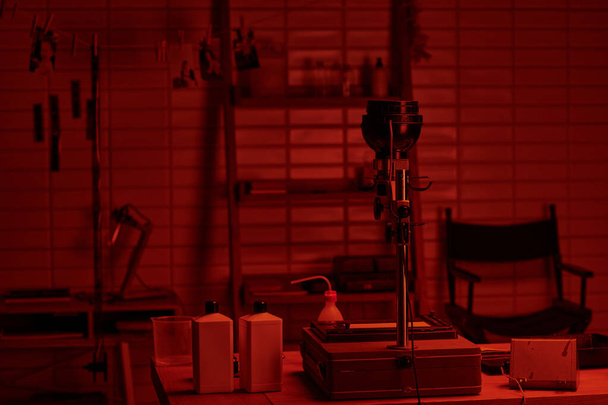 donkere kamer interieur met chemische flessen klaar voor gebruik in het analoge film ontwikkelingsproces - Foto, afbeelding