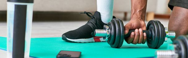 oříznutý pohled na fit afrického Američana ve sportovním oblečení cvičit s činkou doma, prapor - Fotografie, Obrázek
