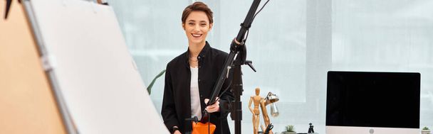 beautiful happy woman with photography equipment smiling cheerfully at camera in her studio, banner - Foto, Imagen