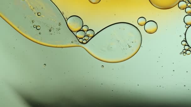 Abstracto colorido aceite de comida gotas burbujas y esferas que fluyen en la superficie del agua - Metraje, vídeo