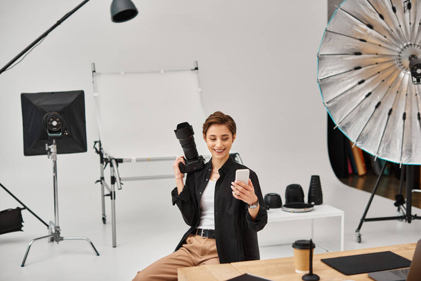 wesoła ładna kobieta fotograf w stroju casual tworzenia opowieści dla mediów społecznościowych w jej studio - Zdjęcie, obraz