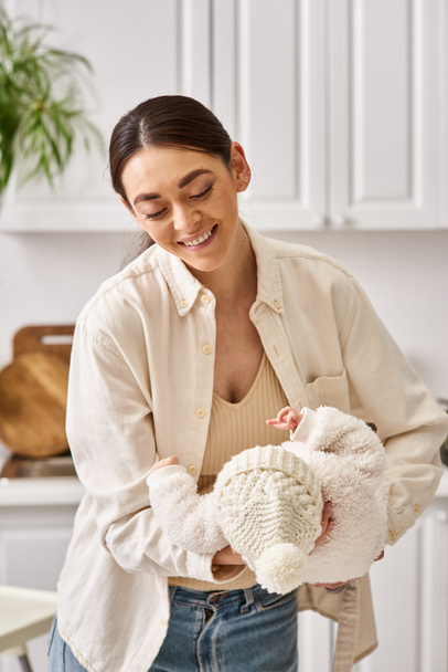 beautiful joyful woman in cozy homewear posing with her cute newborn baby boy, modern parenting - Foto, Imagem