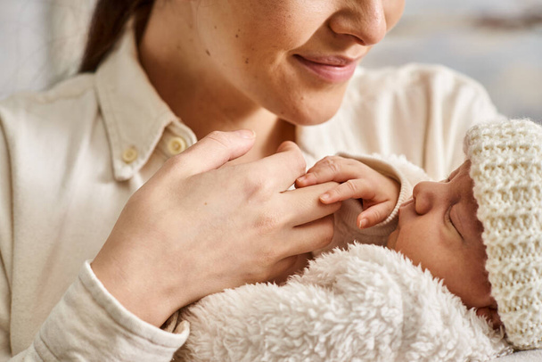 přitažlivá radostná matka v domácím oblečení drží láskyplně svého novorozeného chlapečka, moderní rodičovství - Fotografie, Obrázek