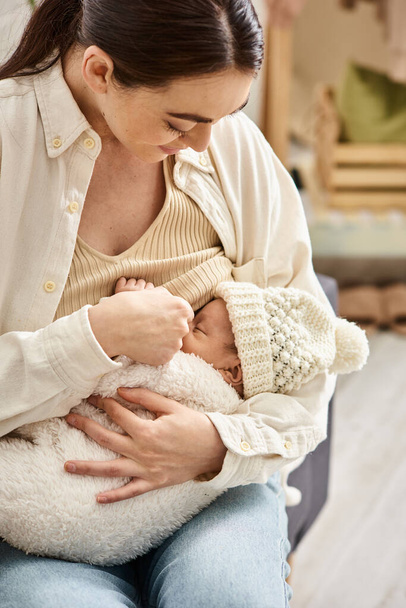 aantrekkelijke liefdevolle vrolijke moeder in gezellige homewear borstvoeding haar pasgeboren kind, moderne ouderschap - Foto, afbeelding