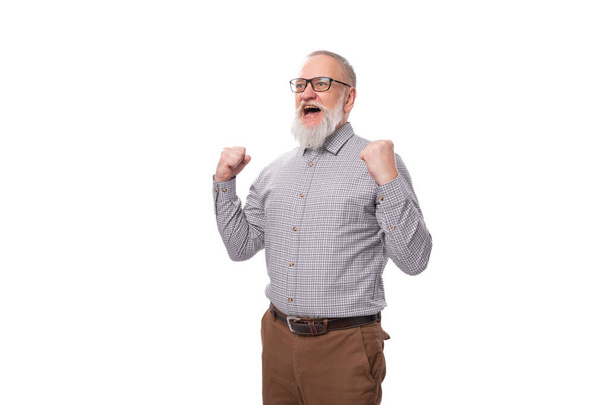 avô bem sucedido com uma barba cinza e bigode em óculos vestidos com uma camisa e calças em um fundo branco. - Foto, Imagem