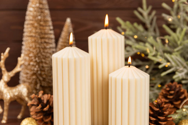 Christmas decoration with candle on texture background. New Year and Christmas candles. Cozy home decor. Burning candle and Christmas decoration. Christmas lights. Copy space.Holiday concept.  - Photo, Image