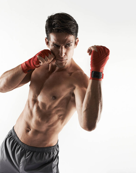 Man, kick boxer and topless in gym, serious and face for workout, boxing and strong. Exercise, sports and training for power, self defense and concentration for challenge, mma and fighting skills. - Photo, Image