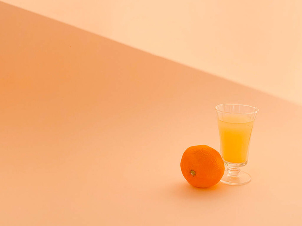 Ένα ποτήρι χυμό πορτοκαλιού και ένα καλαμάκι με πορτοκάλι.. - Φωτογραφία, εικόνα