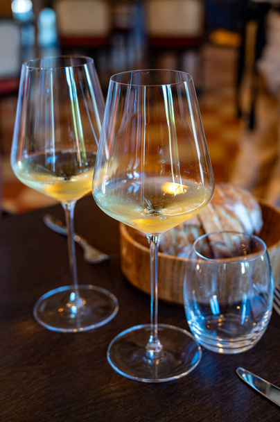 Degustacja białego wina Bordeaux w Sauternes, lewy brzeg ujścia rzeki Gironde we Francji. Szklanki białego słodkiego francuskiego wina serwowane w restauracji - Zdjęcie, obraz