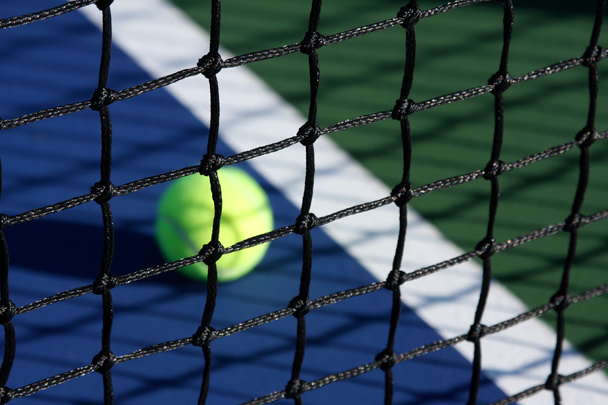 Tennisbaan netto met bal in achtergrond - Foto, afbeelding