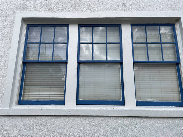 Lakeland, Fla USA - 12 11 23: Windows blue trim stucco εξωτερική υφή φόντου - Φωτογραφία, εικόνα