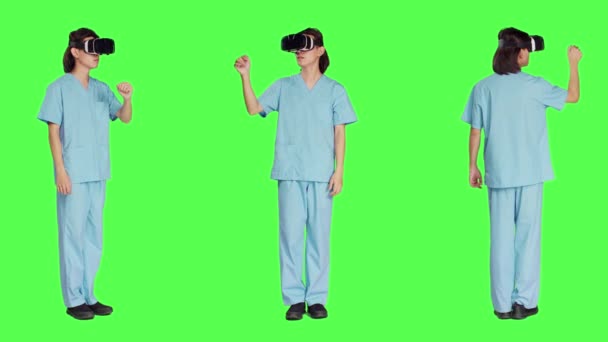 Gelişmiş 3D gözlüklerle çalışan tıp ekibi, yeşil ekran arka planına karşı sanal gerçeklik kulaklığı kullanıyor. Profesyonel sağlık uzmanları tarafından kullanılan yapay zeka.. - Video, Çekim