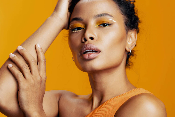 Γυναίκα πρόσωπο ομορφιά αφρικανική κοσμετολογία μόδας δημιουργική μαύρο χώρο μοντέλο όμορφο μακιγιάζ στυλ πορτρέτο δέρμα αντίγραφο καλλυντικά στούντιο χαμόγελο κίτρινο πολύχρωμο - Φωτογραφία, εικόνα