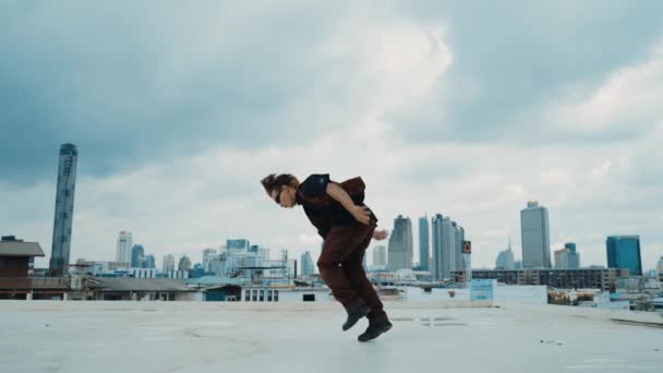 B-boy performance di danza da ballerino di strada professionista sul tetto con grattacielo, vista sulla città. Attraente spettacolo asiatico hipster, muovendo passo energico. Sport all'aperto 2024. Stile hip-hop. ippopotamo. - Filmati, video