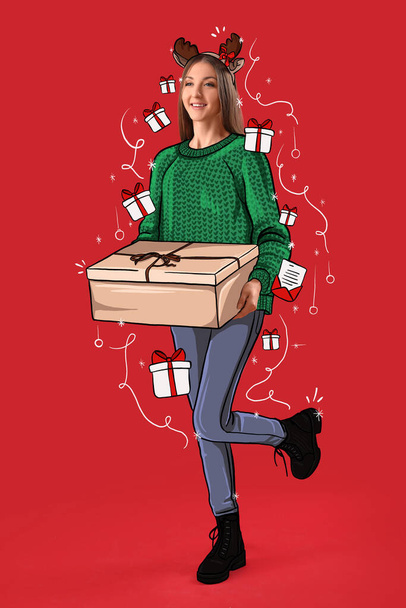 Junge Frau in Rentierhörnern und mit Weihnachtsgeschenk auf rotem Hintergrund - Foto, Bild