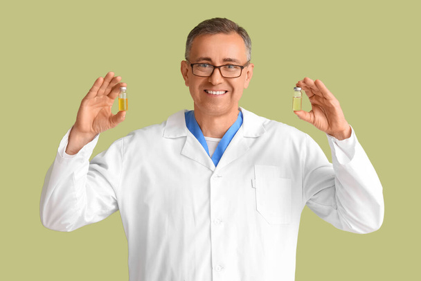 Médico maduro con ampollas sobre fondo verde - Foto, imagen