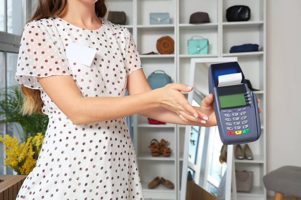 Female seller with payment terminal in clothing shop - Photo, Image