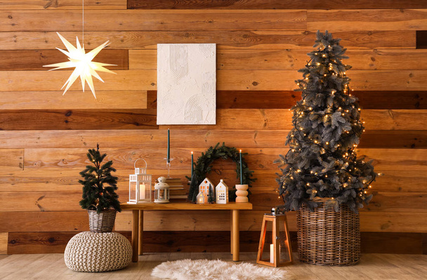 Interior de la habitación festiva con árbol de Navidad y decoraciones cerca de la pared de madera - Foto, imagen