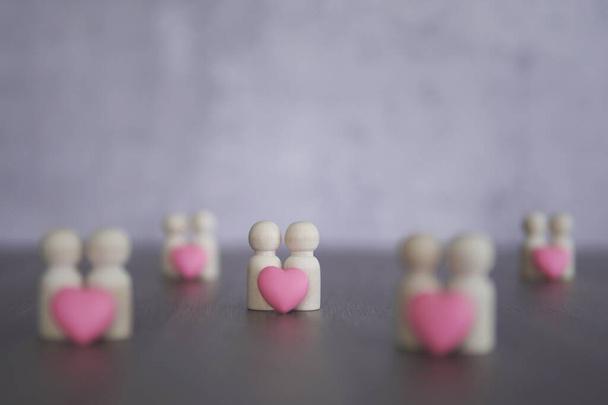 Drewniane lalki i różowe serce z przestrzenią do kopiowania. Miłość, romantyczny, związek, koncepcja pary - Zdjęcie, obraz