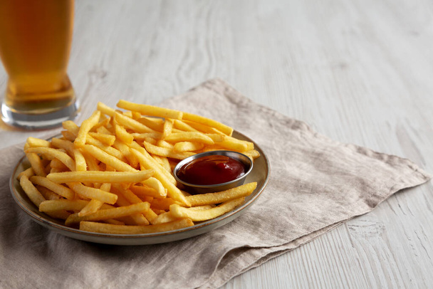 Zelfgemaakte friet met ketchup en koud bier, lage hoek uitzicht. Kopieerruimte. - Foto, afbeelding