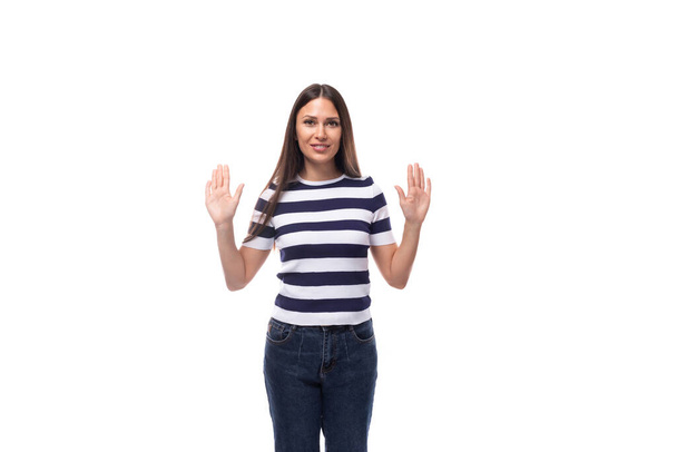 atrakcyjna młoda brunetka kobieta w pasiastej koszulce gestykulująca dłońmi na białym tle z przestrzenią do kopiowania. - Zdjęcie, obraz