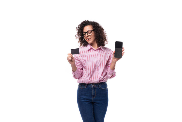 young slender caucasian woman leader holds plastic card and phone. advertising concept. - Photo, Image