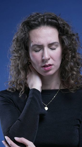 Mujer joven estresada lucha con el dolor de cuello frotando cuerpo sensación de ansiedad - Foto, imagen