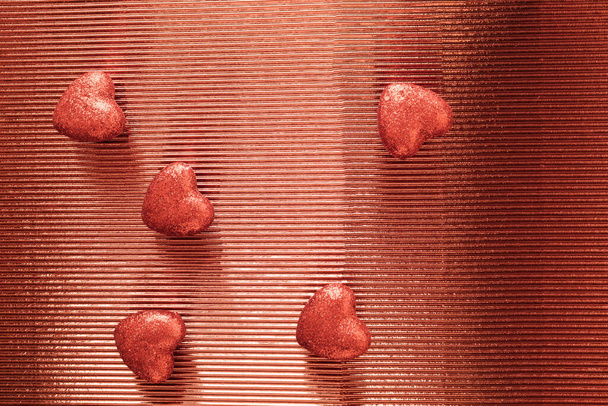 Cuori scintillanti rossi su sfondo lucido. Anniversario e concetto di San Valentino. Composizione minima. Copia spazio - Foto, immagini