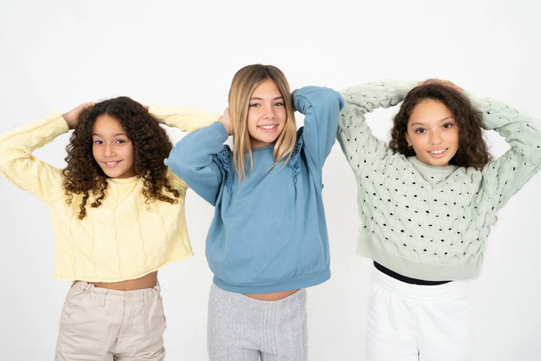 három tinédzser lány kinyújtott karokkal, nyugodt pozícióban. - Fotó, kép
