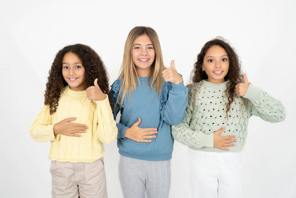 tre ragazze adolescenti felice positivo sorriso mani sulla pancia spettacolo pollice-up bene sano - Foto, immagini