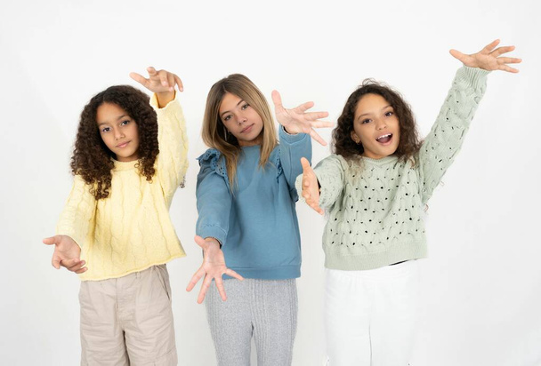tre ragazze adolescenti che guardano la fotocamera sorridendo a braccia aperte per l'abbraccio. Espressione allegra che abbraccia la felicità. - Foto, immagini