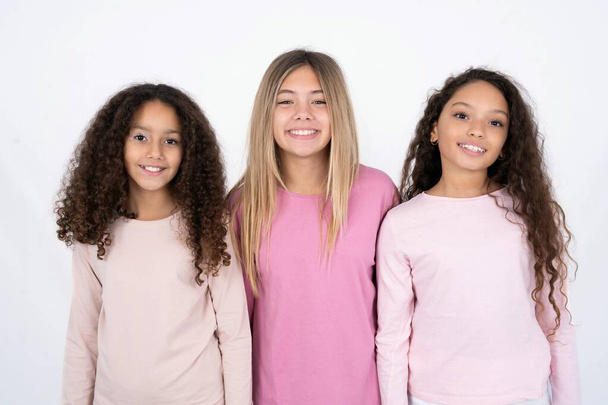 három fiatal lány szép mosollyal elégedett arckifejezéssel. Pozitív érzelmek fogalma - Fotó, kép