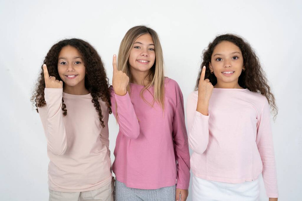 Üç genç kız gülümsüyor ve arkadaş canlısı görünüyor. Bir numara ya da ilk el öne doğru sayıyor, geriye doğru sayıyor. - Fotoğraf, Görsel