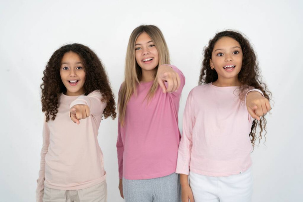 Захоплені позитивні три дівчинки-підлітки вказують на індекс пальця прямо на вас, бачать щось дуже смішне. Вау, дивовижно - Фото, зображення