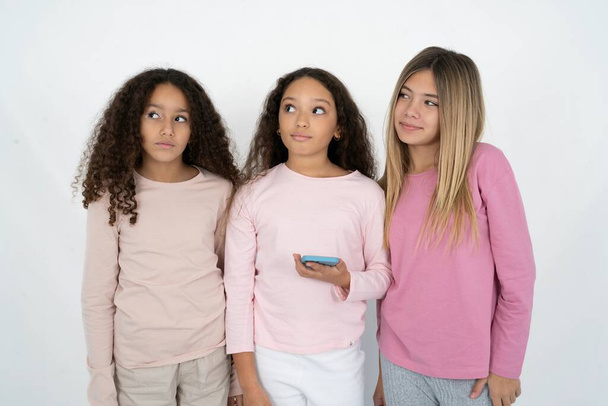 τρία κορίτσια έφηβος κατέχει κινητό τηλέφωνο χρησιμοποιεί υψηλής ταχύτητας internet και τα κοινωνικά δίκτυα έχει online επικοινωνία. Σύγχρονες τεχνολογίες - Φωτογραφία, εικόνα
