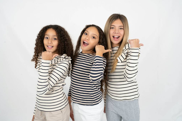Вражені три дівчинки-підлітки вказують на порожній простір - Фото, зображення