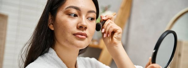 jovem asiático mulher com morena cabelo aplicando maquiagem sobre acne-propenso pele com escova, banner - Foto, Imagem