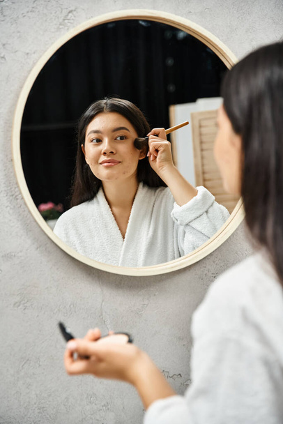 mujer asiática joven con cabello moreno y acné aplicando polvo con cepillo, problemas de piel y maquillaje - Foto, Imagen