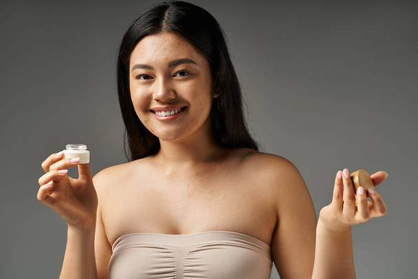 молодая азиатка с брюнетками и прыщавой кожей, смотрящая на зеркало в ванной комнате, баннер - Фото, изображение