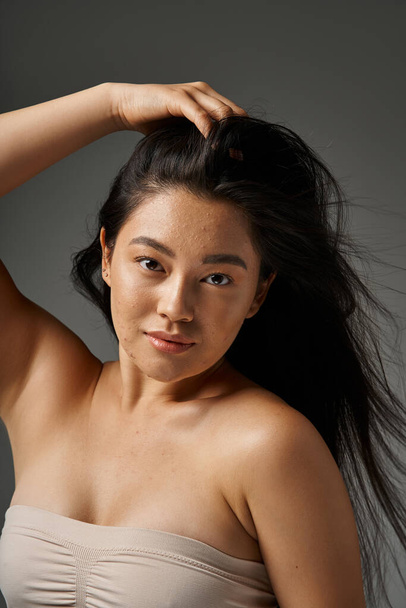 nuori aasialainen nainen ruskeaverikkö hiukset ja akne altis iho katselee peiliä kylpyhuoneessa, banneri - Valokuva, kuva